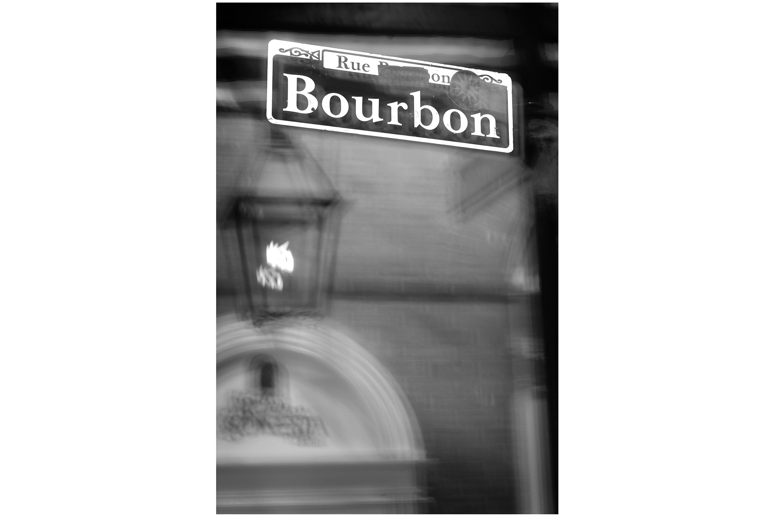 A blurry Bourbon Street sign portends the evening ahead