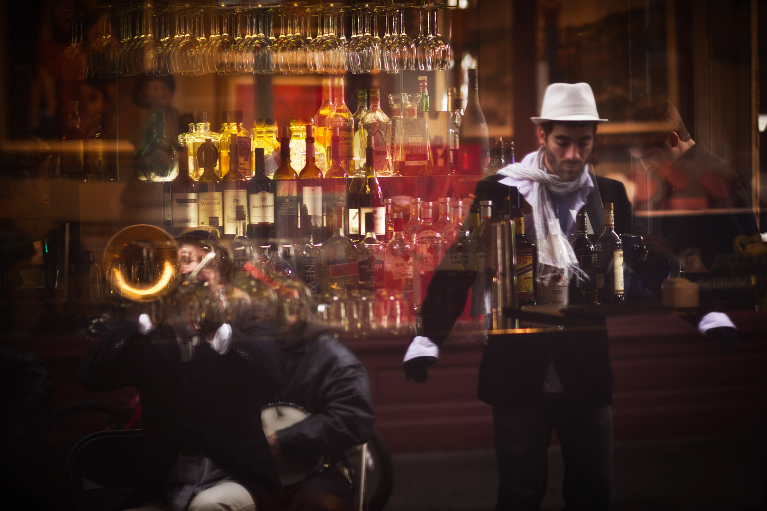 Street buskers entertain while a bartender prepares for the morning rush