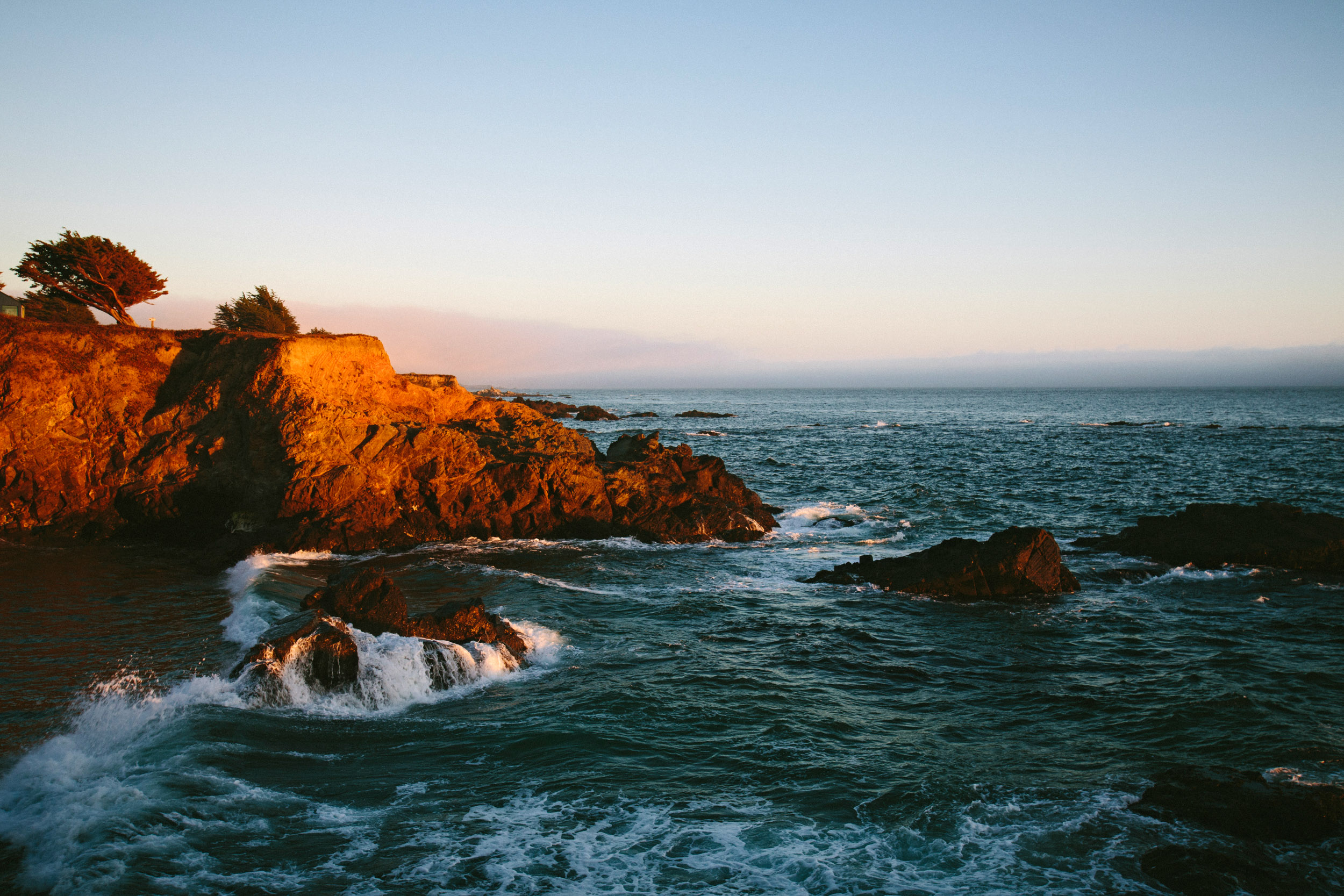 Waves crash on the rocks at sunset in Sea Ranch, northern California